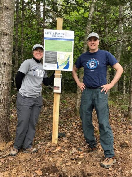 two adults smile at trailhead