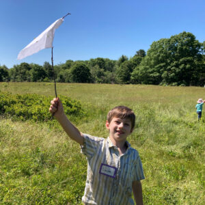 boy smiles waving flag