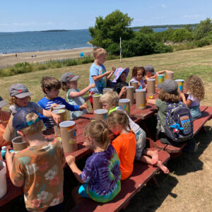 children paint containers at picnic table