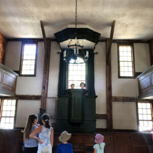children stand at historical society pulpit