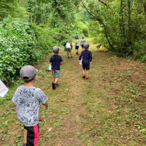 children walk trail through woods