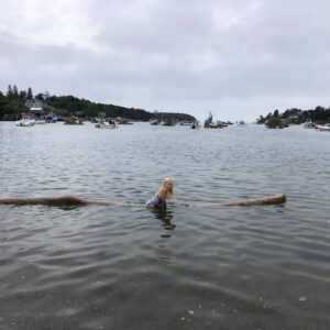 child swims to floating log