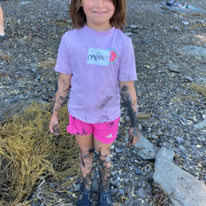 mud covered child smiles