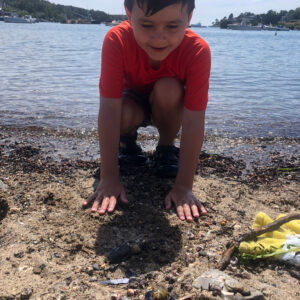 child builds sand castle at waters edge