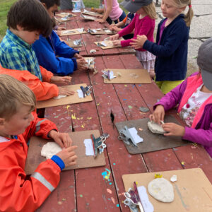 children mold clay at picnic table