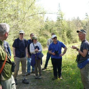 man speaks to group of adults on trail