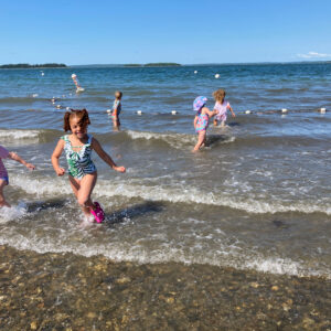children run and play in shallow water