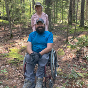 man in wheelchair and woman smile for camera