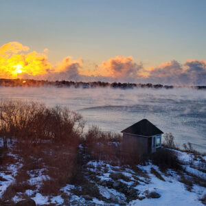 sunrise over water covered in sea smoke