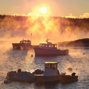 sea smoke around boats at sunrise