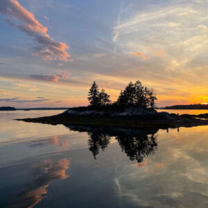 sunset over island of pine trees