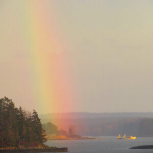 rainbow ends in water on hazy day