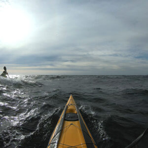 view from seat of kayak looking out into water on cloudy day