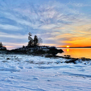 snow and ice lead out to island at sunset