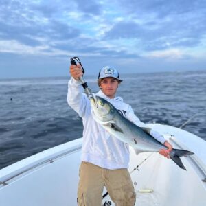 man holds fish on boat