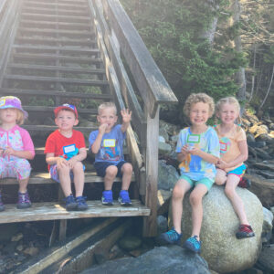children smile on staircase to beach