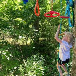 girl climbs at forest playground