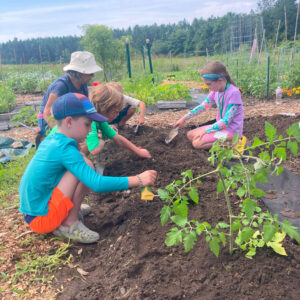 children help plant at community garden