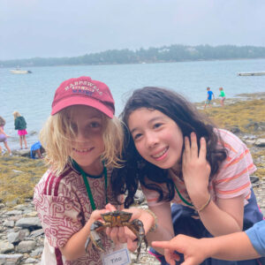two girls holding crab smile at camera