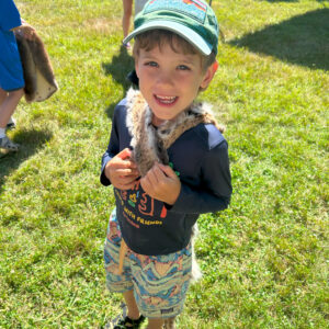 boy holding fur smiles at camera