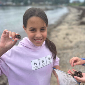 girl holding hermit crab smiles for camera