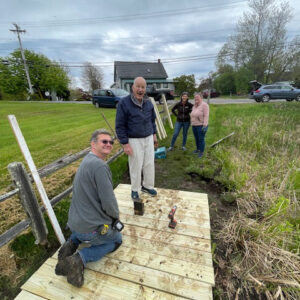 two men look at camera while building a ramp