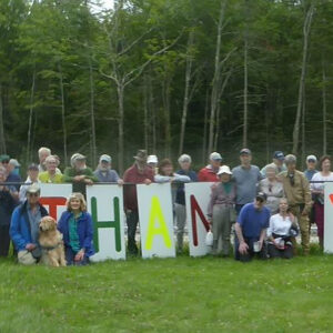group of people stand with large letters spelling THANK YOU