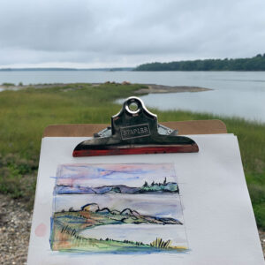 small watercolor on a clipboard with marsh in the background