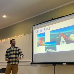 Man gestures toward his powerpoint presentation