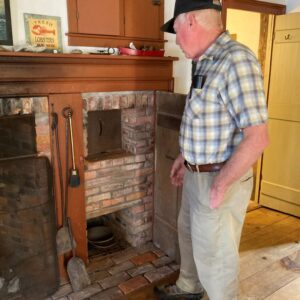 man stands in front of historic fireplace
