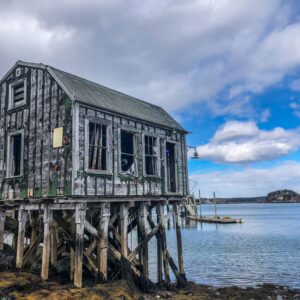 fish house sits on tall pylons over water at low tide